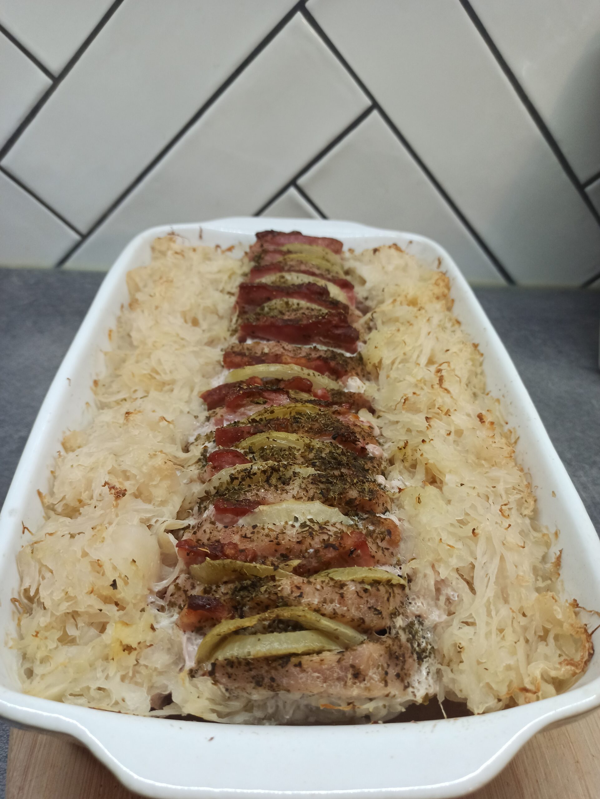 Schab pieczony z boczkiem i cebulą w kiszonej kapuście